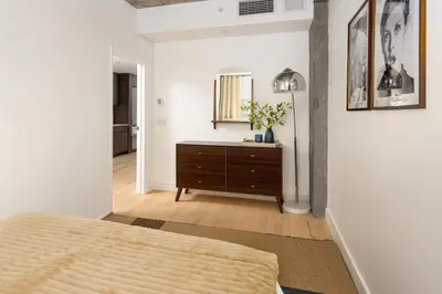 a bedroom with a bed and a dresser and a mirror at Luxury Full Floor Chelsea with WasherDryer 2bd in New York