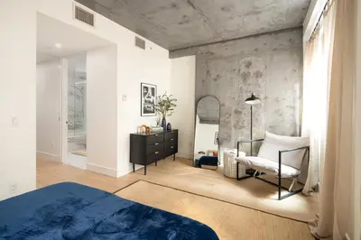 a bedroom with a bed and a chair and a mirror at Luxury Full Floor Chelsea with WasherDryer 2bd in New York
