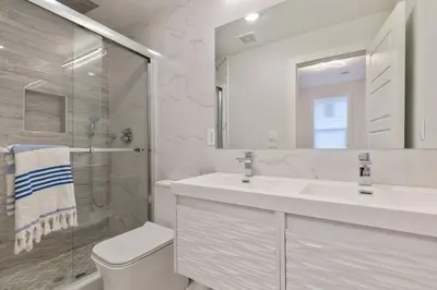 a bathroom with a toilet and a sink and a shower at Modern & Spacious 3 BED & 2 BA Condo mins from NYC in Jersey City