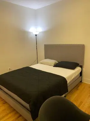 a bedroom with a bed with a lamp and a chair at Modern & Spacious 3 BED & 2 BA Condo mins from NYC in Jersey City