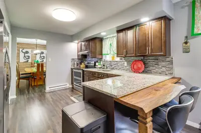 a kitchen with wooden cabinets and a wooden table at Long Pond Home with Hot Tub about 8 Mi to Kalahari! in Long Pond