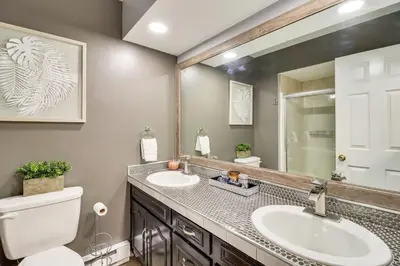 a bathroom with two sinks and a toilet and a mirror at Long Pond Home with Hot Tub about 8 Mi to Kalahari! in Long Pond