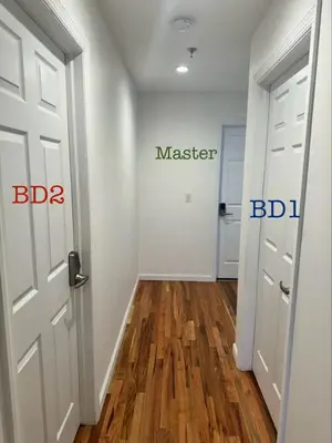 a hallway with a door with master and bdi signs on it at Harmony in the Heights - Master in Newark