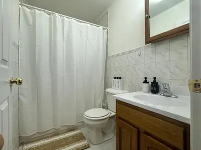 a white bathroom with a toilet and a sink at Harmony in the Heights - Master in Newark