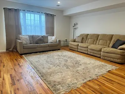 a living room with two couches and a rug at Harmony in the Heights - Master in Newark