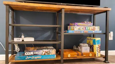 a shelf with a tv and boxes on it at Birchwood by AvantStay Game Room Lake Access in Blakeslee