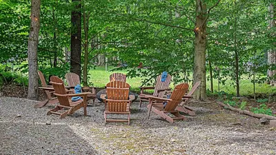 a group of chairs sitting in the woods at Birchwood by AvantStay Game Room Lake Access in Blakeslee