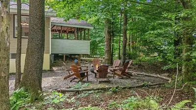a group of chairs and tables in front of a house at Birchwood by AvantStay Game Room Lake Access in Blakeslee