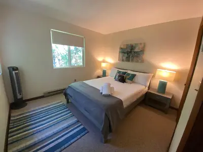 a bedroom with a bed and two lamps and a television at Ash Cottage in Poconos near Camelback & Kalahari in Long Pond