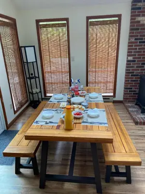 a wooden table with plates and a vase on it at Ash Cottage in Poconos near Camelback & Kalahari in Long Pond