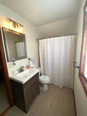 a bathroom with a sink and a toilet and a mirror at Ash Cottage in Poconos near Camelback & Kalahari in Long Pond