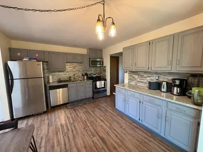 a kitchen with blue cabinets and a stainless steel refrigerator at Ash Cottage in Poconos near Camelback & Kalahari in Long Pond