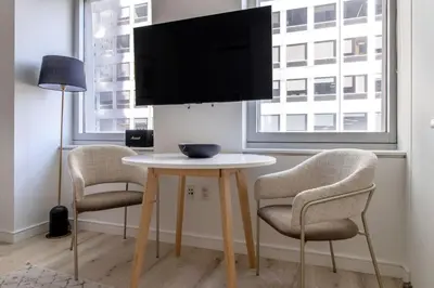 a table with two chairs and a tv on top at Midtown West 1br w gym wd nr bryant park NYC-1380 in New York