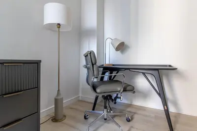 a desk with a chair and a lamp in a room at Midtown West 1br w gym wd nr bryant park NYC-1380 in New York