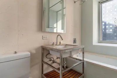 a bathroom with a sink and a toilet and a mirror at Midtown West 1br w gym wd nr bryant park NYC-1380 in New York