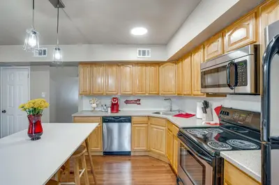 a kitchen with wooden cabinets and stainless steel appliances at Walk to Mall and Train Station! Philly Suburb Stay in Willow Grove