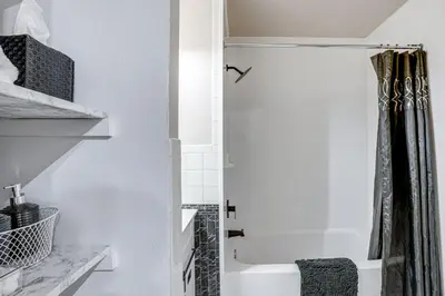 a white bathroom with a shower with a shower curtain at Walk to Mall and Train Station! Philly Suburb Stay in Willow Grove