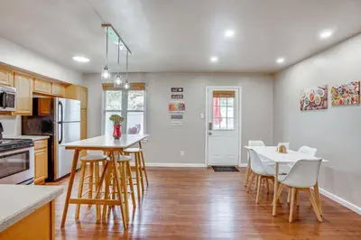 a kitchen with wooden stools and a table and chairs at Walk to Mall and Train Station! Philly Suburb Stay in Willow Grove