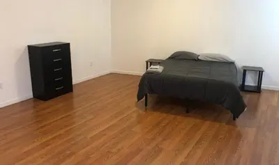 a bedroom with a bed and a dresser in a room at Large apartment, sleeps up to 8 people comfortably, direct NYC Manhattan train only 5 minute walk away, MetLife Stadium FIFA World Cup 25 minutes away in Elizabeth