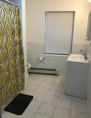 a bathroom with a shower and a sink and a toilet at Large apartment, sleeps up to 8 people comfortably, direct NYC Manhattan train only 5 minute walk away, MetLife Stadium FIFA World Cup 25 minutes away in Elizabeth