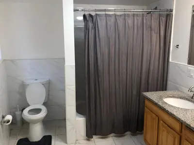 a bathroom with a shower curtain and a toilet at Large apartment, sleeps up to 8 people comfortably, direct NYC Manhattan train only 5 minute walk away, MetLife Stadium FIFA World Cup 25 minutes away in Elizabeth