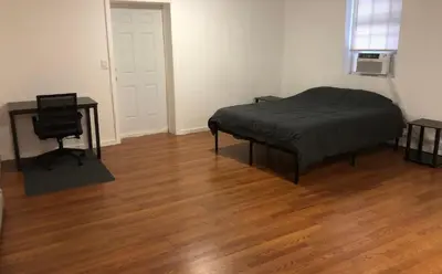 a bedroom with a bed and a desk and a chair at Large apartment, sleeps up to 8 people comfortably, direct NYC Manhattan train only 5 minute walk away, MetLife Stadium FIFA World Cup 25 minutes away in Elizabeth