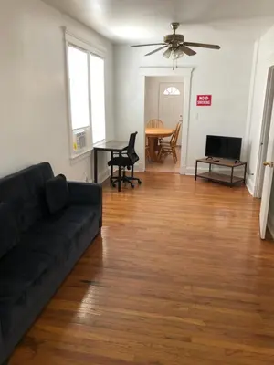 a living room with a black couch and a table at Private 2 bedroom and 1 bathroom house in a quiet area and convenient to NYC bus and train, MetLife Stadium FIFA World Cup 35 minutes away in Perth Amboy