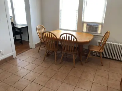 a wooden table and chairs in a dining room at Private 2 bedroom and 1 bathroom house in a quiet area and convenient to NYC bus and train, MetLife Stadium FIFA World Cup 35 minutes away in Perth Amboy