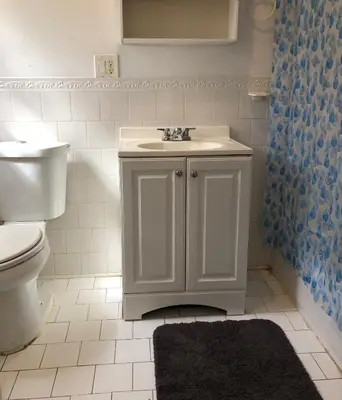 a bathroom with a white sink and a toilet at Private 2 bedroom and 1 bathroom house in a quiet area and convenient to NYC bus and train, MetLife Stadium FIFA World Cup 35 minutes away in Perth Amboy