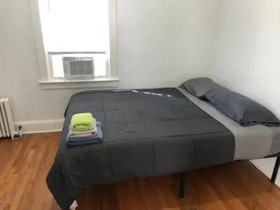a bed in a room with a window at Private 2 bedroom and 1 bathroom house in a quiet area and convenient to NYC bus and train, MetLife Stadium FIFA World Cup 35 minutes away in Perth Amboy