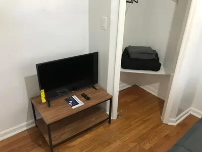 a living room with a television on a table at Private 2 bedroom and 1 bathroom house in a quiet area and convenient to NYC bus and train, MetLife Stadium FIFA World Cup 35 minutes away in Perth Amboy