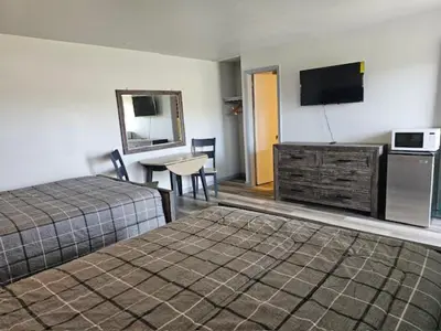 a hotel room with a bed and a tv and a table at Motel 81 in Dalton
