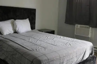 a bedroom with a bed with a white comforter at Motel 81 in Dalton