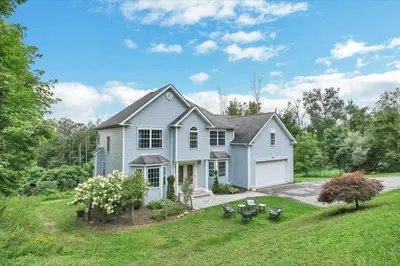 a blue house with a porch and a yard at Spacious 6 BR Villa - Serene Scenic Mountain Escape in Bloomingburg