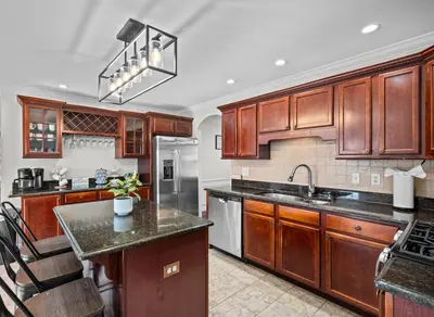 a kitchen with wooden cabinets and a counter top at Spacious 6 BR Villa - Serene Scenic Mountain Escape in Bloomingburg