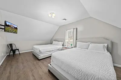 a white bedroom with two beds and a window at Spacious 6 BR Villa - Serene Scenic Mountain Escape in Bloomingburg