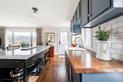 a kitchen with black cabinets and a counter top at Hillcrest Cottage - Charming Cottage with hot tub and view! in Obernburg