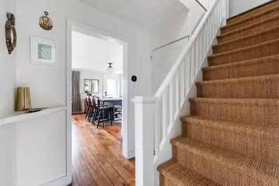 a staircase in a home with white walls and wood floors at Hillcrest Cottage - Charming Cottage with hot tub and view! in Obernburg