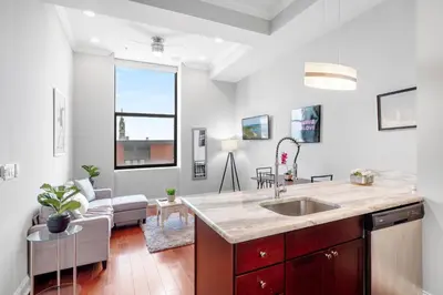 a kitchen with a sink and a living room at Nice 1BR Luxury Flat - Pool & Gym in Philadelphia