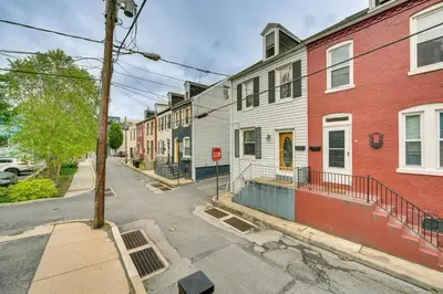 an empty city street with houses and a stop sign at Chic Lancaster Vacation Rental, Walkable Location! in Lancaster