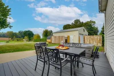 a patio with a table and chairs on a deck at Nature Haven Pond,Pool and Hot Tub in Myerstown