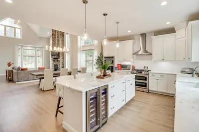 a large kitchen with white cabinets and a dining room at BBQ-Ready Deck Lake Harmony Home with Fire Pit in Lake Harmony