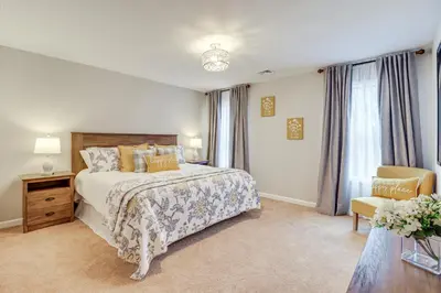 a bedroom with a large bed and a chair at BBQ-Ready Deck Lake Harmony Home with Fire Pit in Lake Harmony