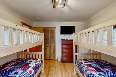 a bedroom with two bunk beds and a tv at Mountain Home at Camelback in Tannersville