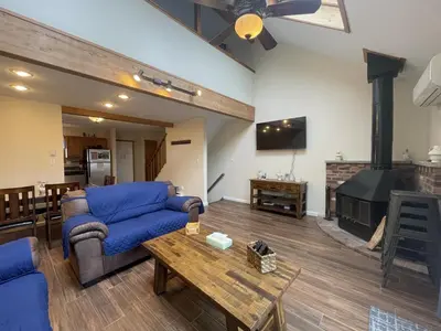 a living room with a blue couch and a fireplace at Mountain Home at Camelback in Tannersville