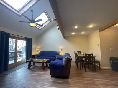 a living room with a blue couch and a table at Mountain Home at Camelback in Tannersville