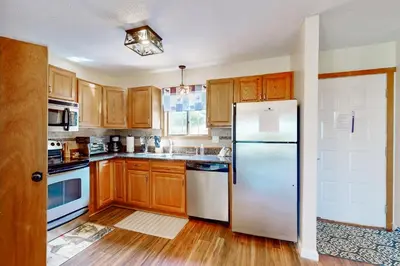 a kitchen with wooden cabinets and a white refrigerator at Mountain Home at Camelback in Tannersville