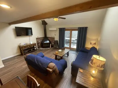 a living room with two blue couches and a fireplace at Mountain Home at Camelback in Tannersville