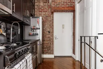 a kitchen with a stove and a brick wall at Lovely Room at 3 bedroom Apt at the heart of East Village in New York