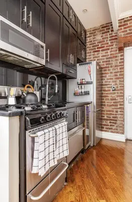 a kitchen with a stove and a refrigerator at Lovely Room at 3 bedroom Apt at the heart of East Village in New York